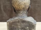 sculpture of a man ' s head with a green marker on it