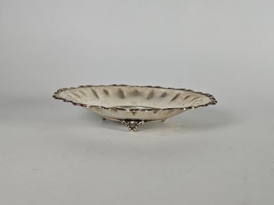une assiette en argent avec un motif décoratif sur le bord
