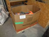 a cardboard box filled with assorted items inside of a garage