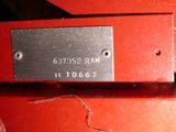 a close up of a red box with a metal tag on it