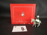 une petite figurine représentant un homme à cheval, à côté d'une boîte rouge