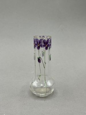 a glass vase with purple flowers in it on a table