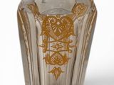 a glass cup with a gold design on it