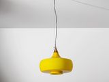 une lampe jaune suspendue au plafond dans une pièce blanche