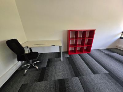 un bureau avec une chaise et une bibliothèque dans un coin de la pièce