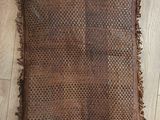 an old woven rug with fringes on a wooden floor