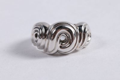 gros plan d'une bague en argent sur une surface blanche