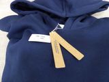 blue hoodie with a tag on it sitting on a white surface