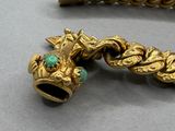 gold bracelet with a dragon head and a turquoise stone bead