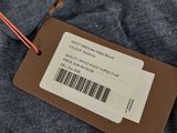 un gros plan sur l'étiquette d'une chemise bleue ornée de fleurs orange