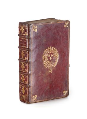 un vieux livre avec un emblème en or sur la couverture