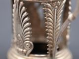 close up of a silver teapot with a bird on top of it