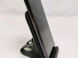 a close up of a cell phone on a stand on a table