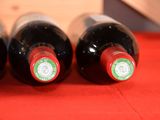 three bottles of wine are lined up on a red table