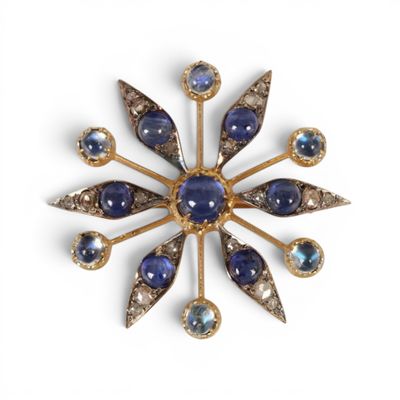 une image représentant une broche ornée de pierres bleues et d'or
