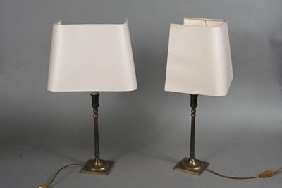 pair of brass table lamps with white lampshads on each of them