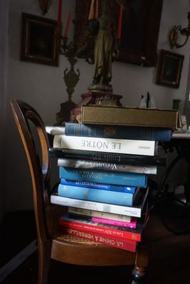 une pile de livres posée sur une chaise en bois