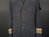 a military uniform on a mannequin stand with a black background