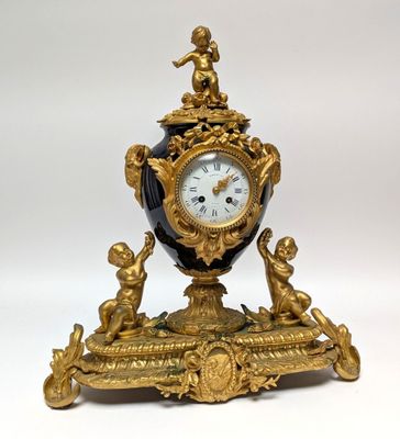 a gold and black clock sitting on top of a table