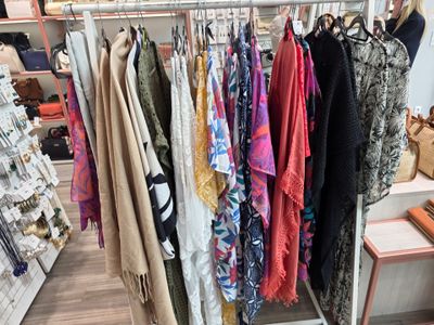 beaucoup de vêtements suspendus à une étagère dans un magasin