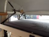 a bed in the back of a camper van with a mattress on it