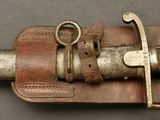 a very old looking knife with a leather sheath on it