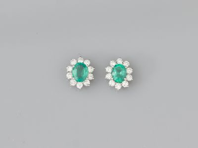 a pair of emerald and diamond earrings