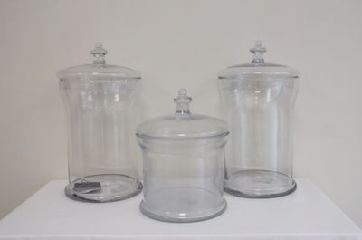 trois bocaux en verre posés sur une table blanche