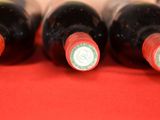several bottles of wine are lined up on a red surface