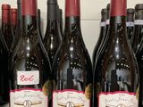 plusieurs bouteilles de vin sont alignées sur une étagère