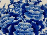 a blue and white plate with flowers and birds on it
