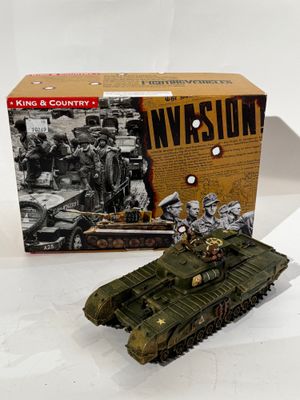 un char de guerre miniature devant une boîte sur laquelle figure une image de soldats