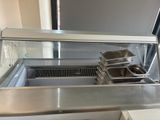 stainless steel counter top with three trays of food on it