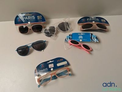 Plusieurs paires de lunettes de soleil et une paire de lunettes de soleil sont posées sur une table