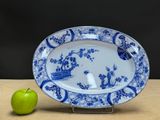 a blue and white plate with a green apple next to it