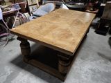 une grande table en bois avec un piètement en bois, placée au milieu d'une pièce