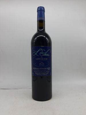 une bouteille de vin rouge posée sur une table blanche