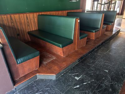 une rangée de bancs verts dans un coin d'un restaurant