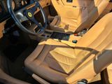 beige leather interior of a sports car with a steering wheel and dashboard