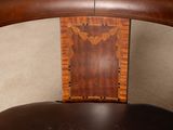 a wooden chair with a black seat and a brown back