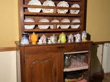 une armoire en bois sur laquelle sont posées des assiettes, dans une pièce