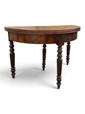 a wooden table with turned legs and a curved top