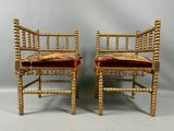 une paire de chaises dorées avec des coussins en velours rouge