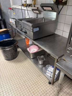 une cuisine avec de nombreux plans de travail en inox