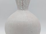 a white vase that has a light on top of it