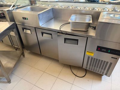 une grande cuisine avec de nombreux plans de travail en inox