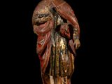 an old wooden statue of a man with a hat and robe