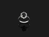a black and white diamond ring on a black surface