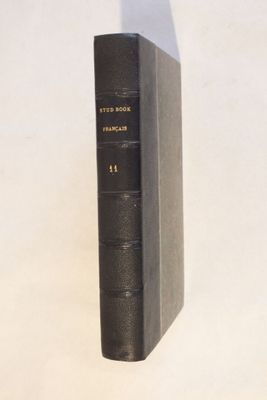 un vieux livre noir posé sur une table blanche