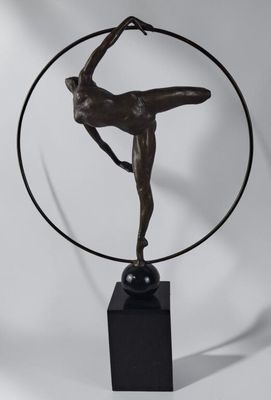 une sculpture en bronze représentant une femme portant un jupon à cerceaux, posée sur un socle en marbre